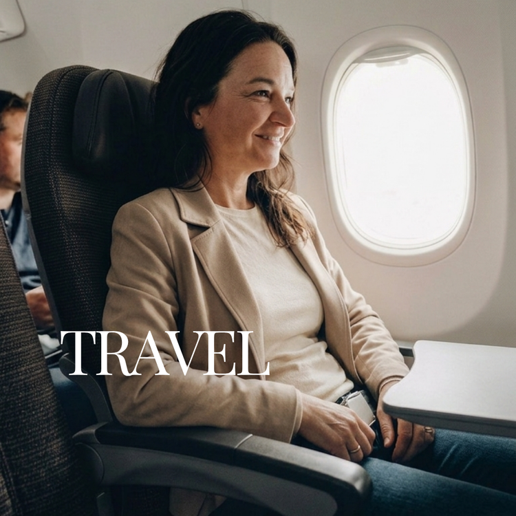 A woman sitting in an airplane seat by the window, wearing a beige blazer over a cream top. The word 'TRAVEL' is overlaid in white text across the lower left.